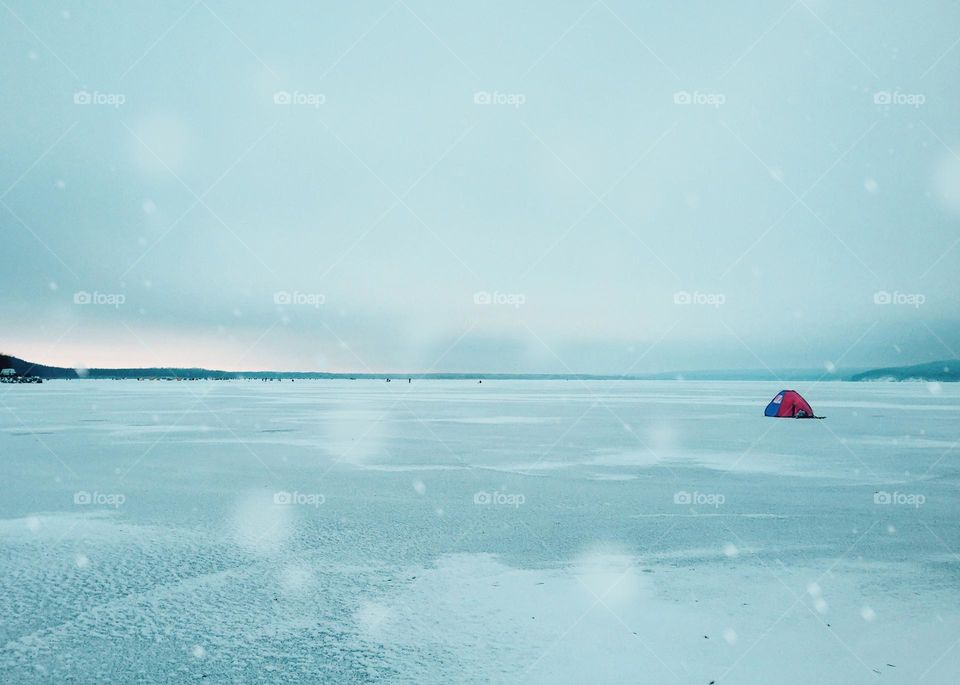 Red tent on frozen lake 