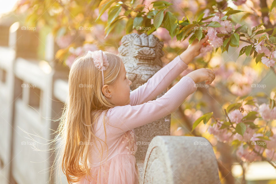 Cute little girl with blonde hair outdoor on spring time