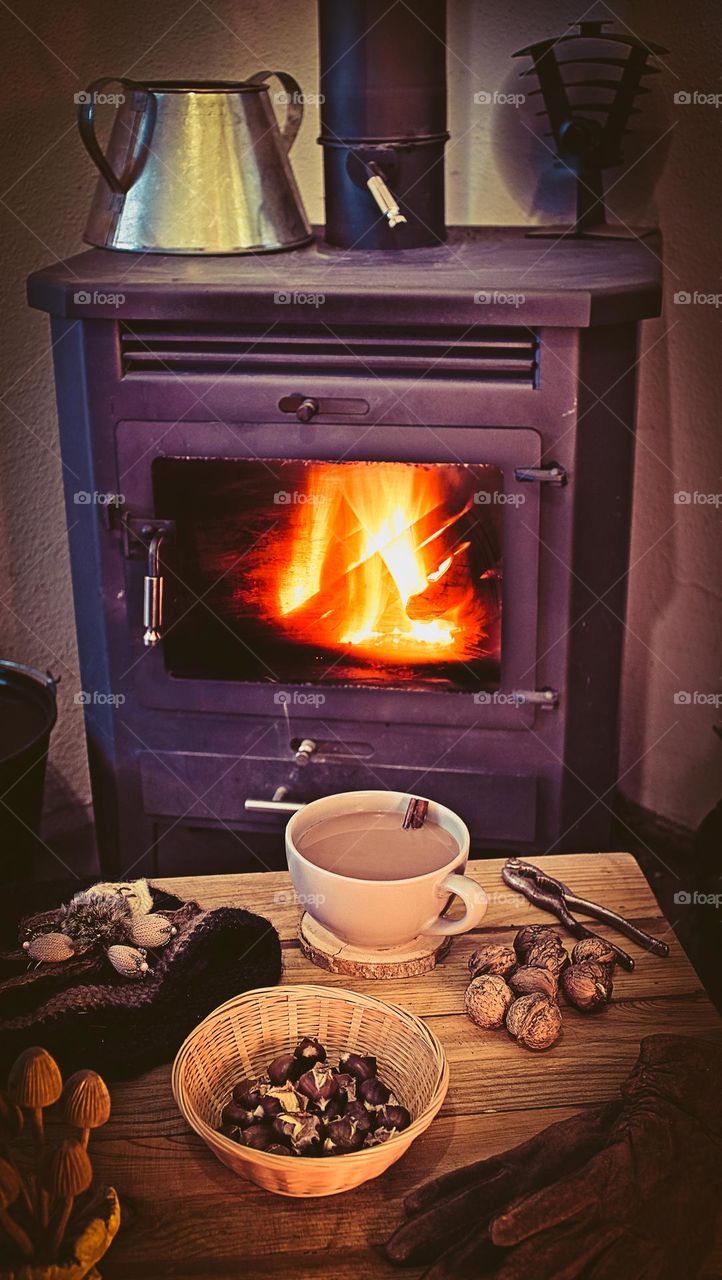 A hot drink and nutty snacks next to the log burner