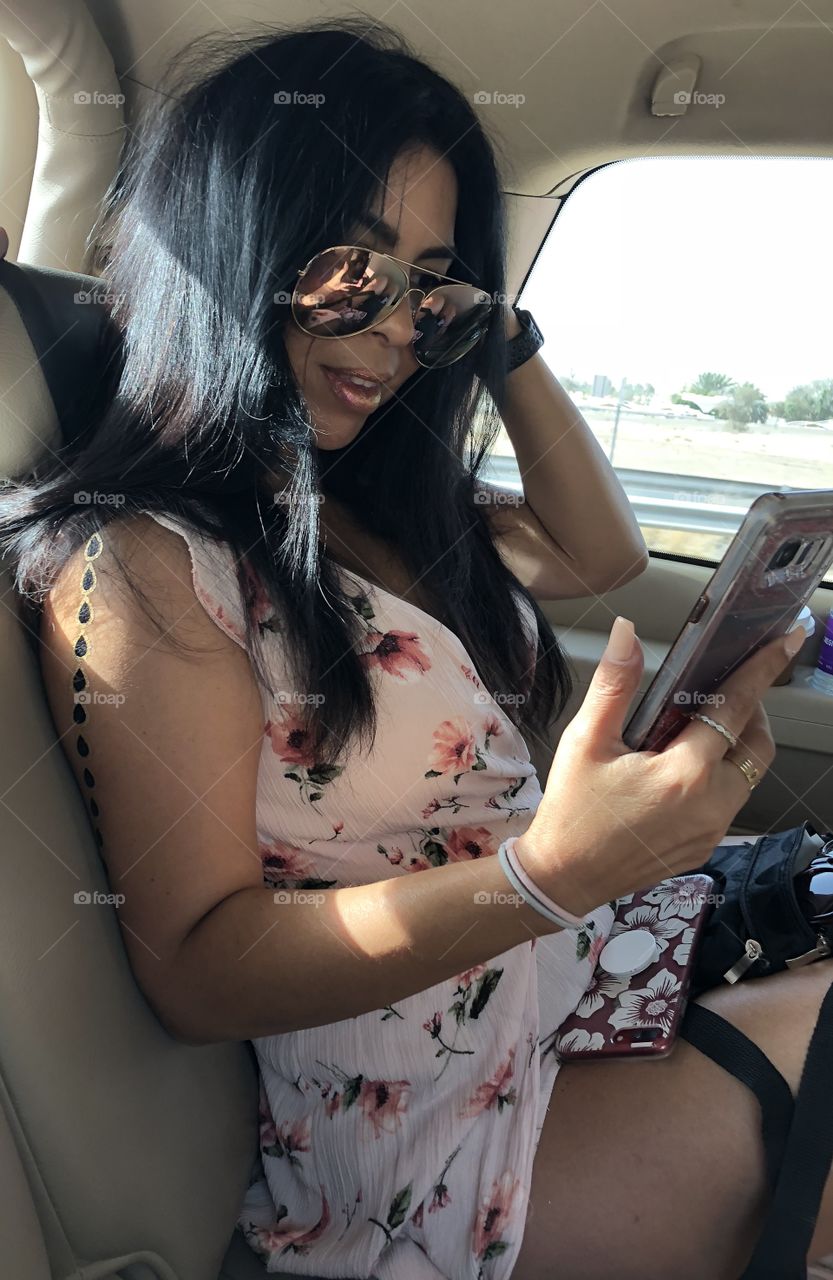 Busy life, vacationing and connected. Executive life. Luxury vacation. Dubai trip and metallic tattoo stamp to blend in. iPhone, technology, eyewear.