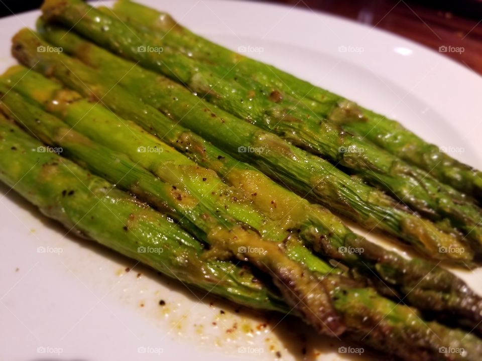 Yummy Green Seasoned Asparagus Spears on a White Plate