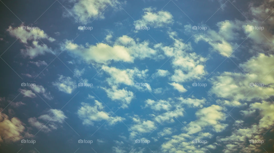 Large clouds float across the sunset sky like sails.