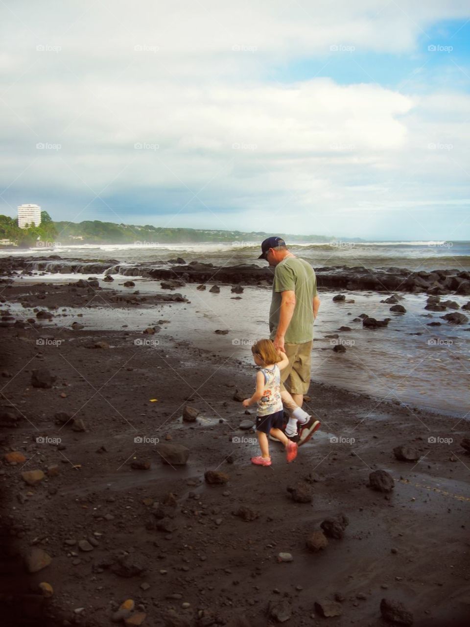 Father and child strolling on the beach in Hawaii