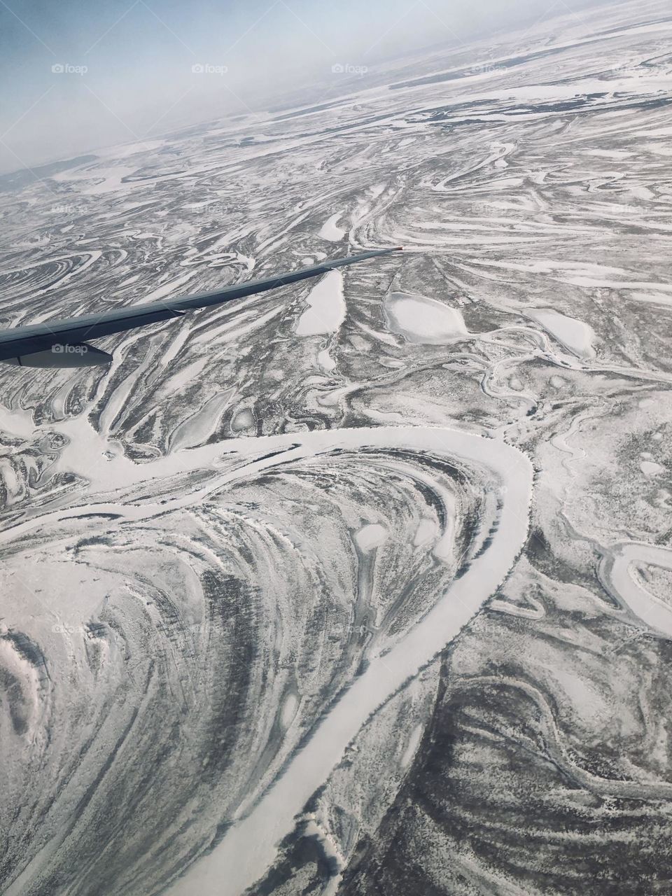 Под крылом самолёта тайга и река 