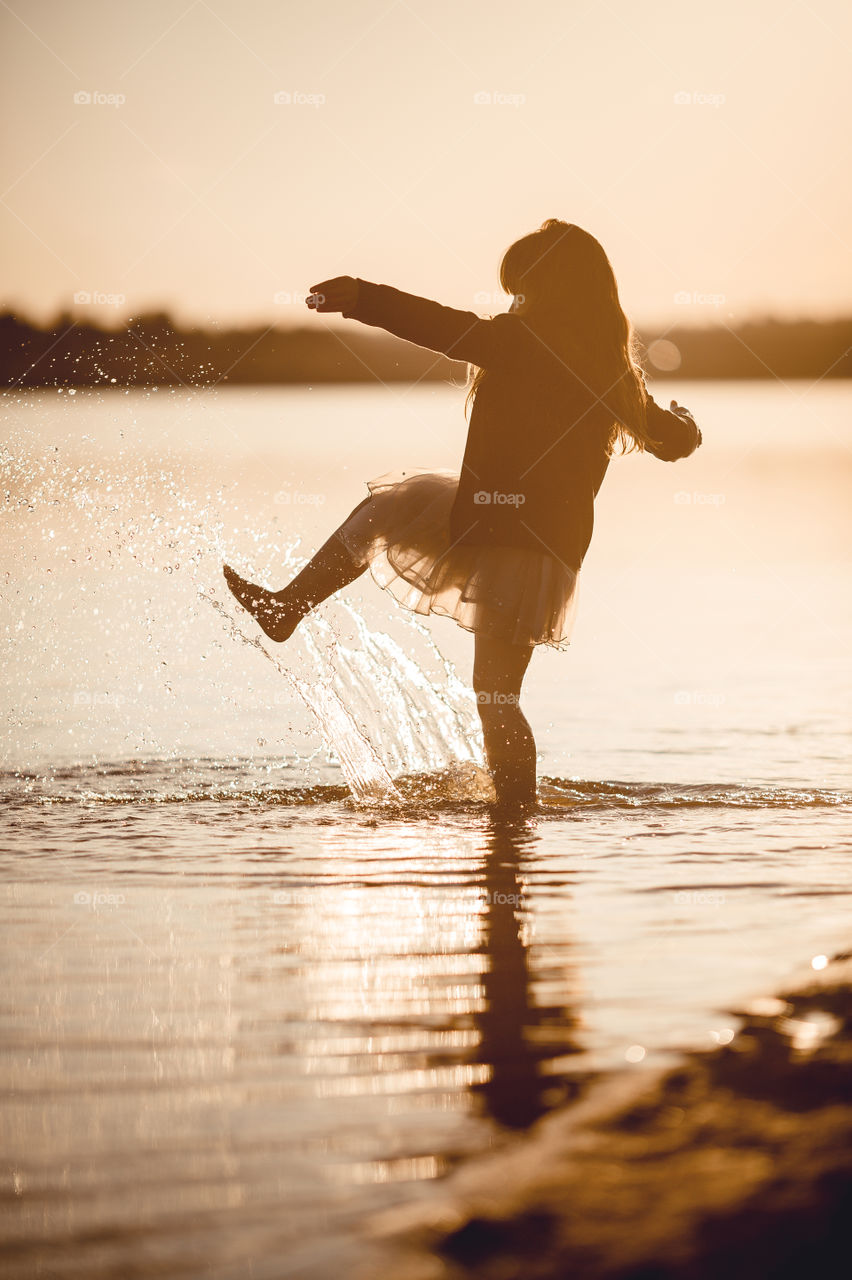 Little girl on lake coast