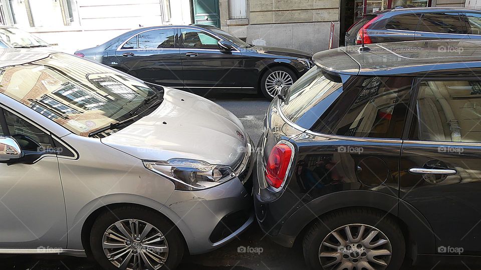 Cars with soul - Two cars are bumper-to-bumper in Paris where parking is limited