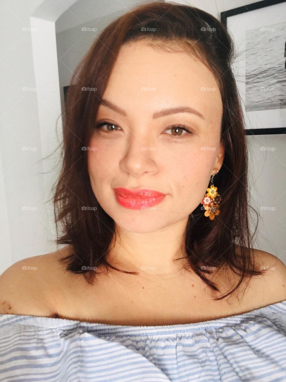 Woman with recycled plastic earring in the shape of flowers.