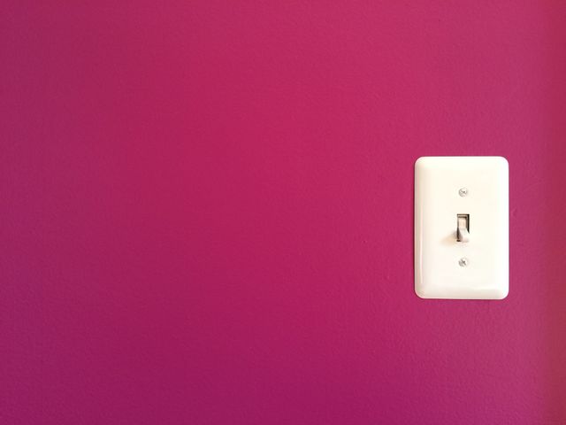 Close-up of pink wall and light switch
