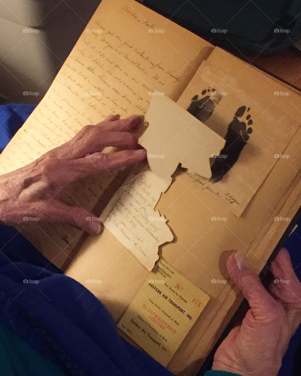 An elderly woman looking at her baby scrapbook 