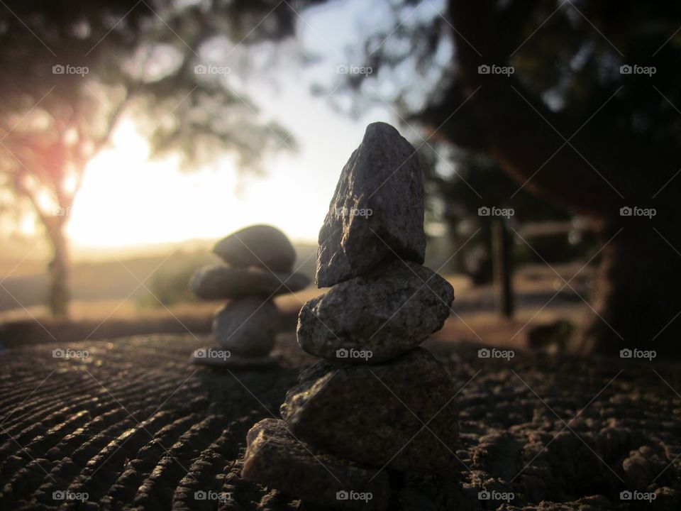 Zen rock stacking at sunset 