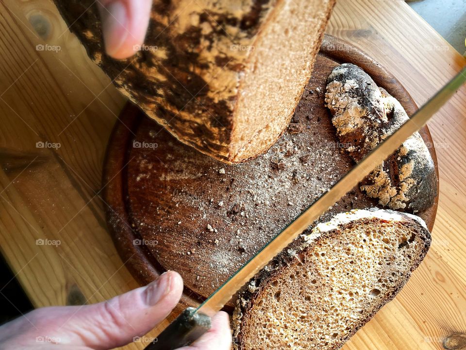 Close up of fresh dark bread being sliced