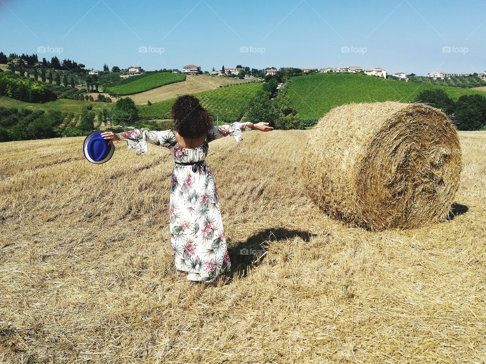 Woman with open arms in a wheat field