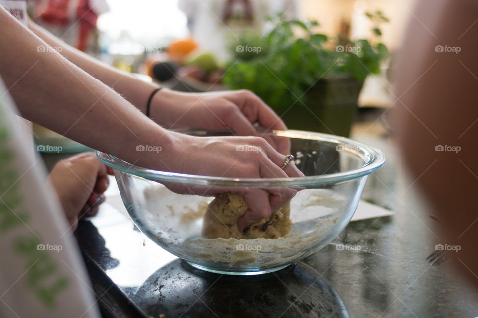 A woman is in the kitchen baking and cooking homemade scones with fruit and fresh herbs