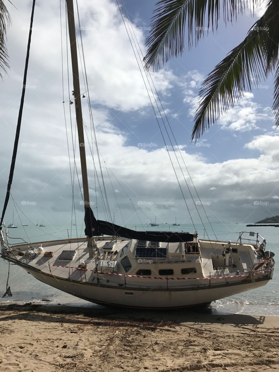 Damaged sailboat listing; aftermath wake of cyclone Debbie in Queensland south Australia 2017 editorial 