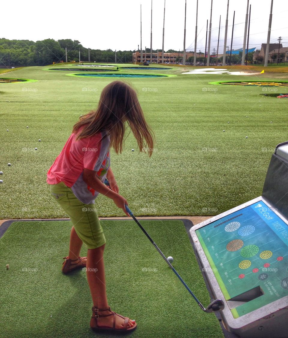 Golf girl. Girl playing golf at Top Golf