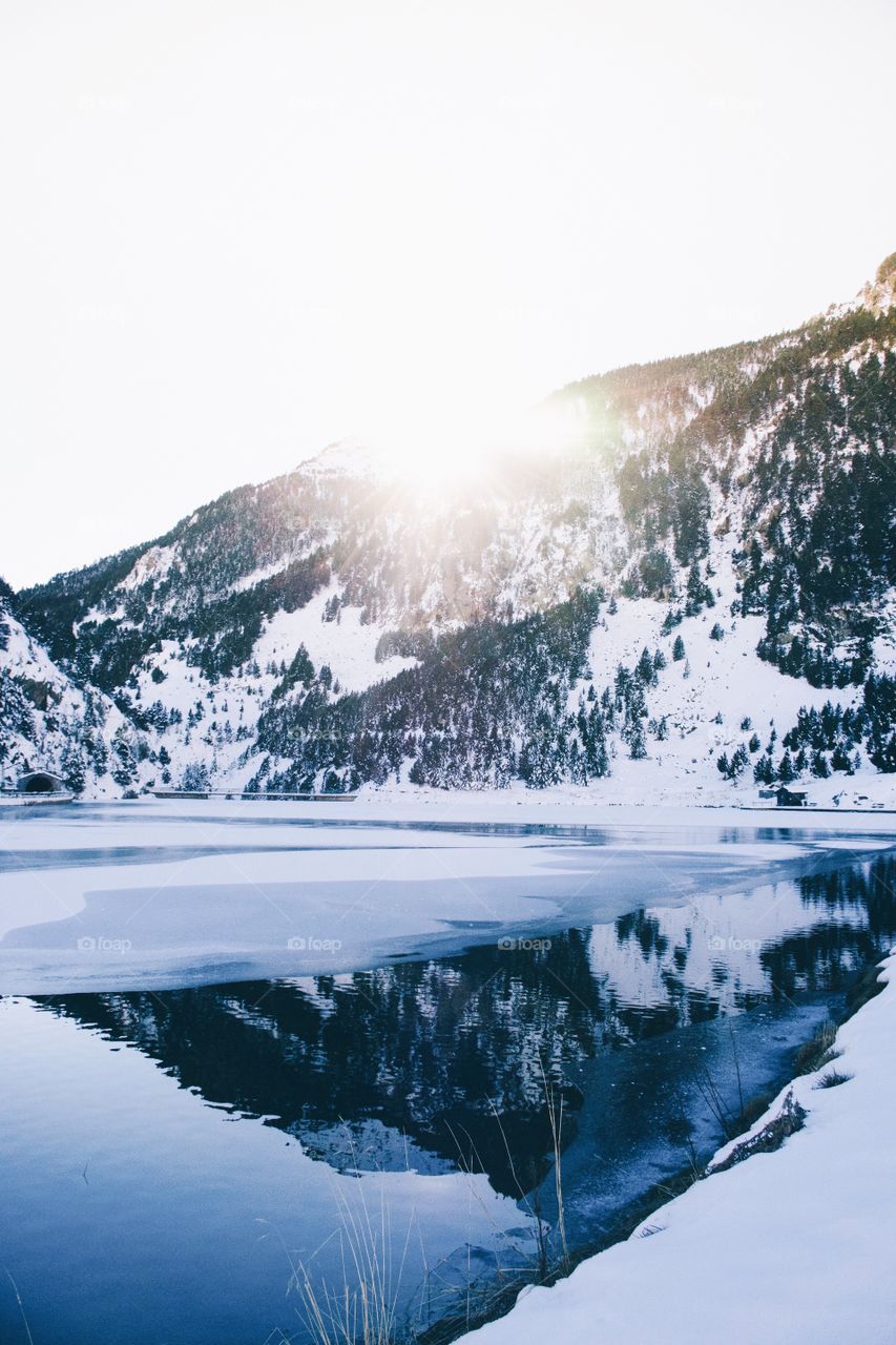 Reflection of mountain on frozen lake
