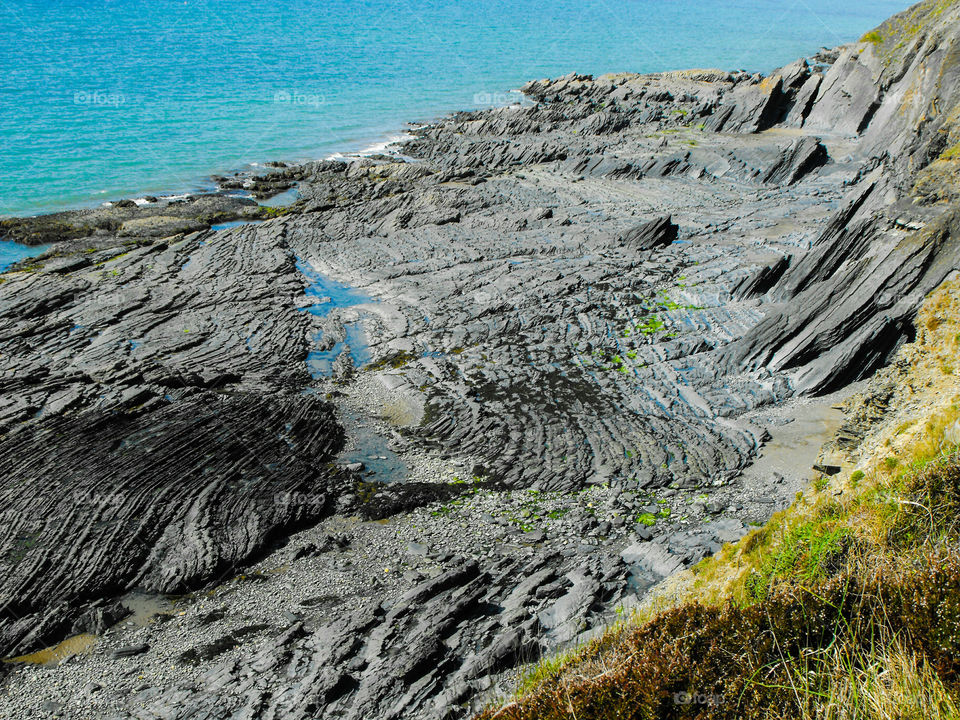 A slate beach with layers as seen from a cliff