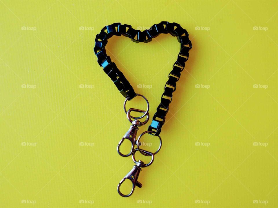 beautiful black heart shape by key chain with yellow background