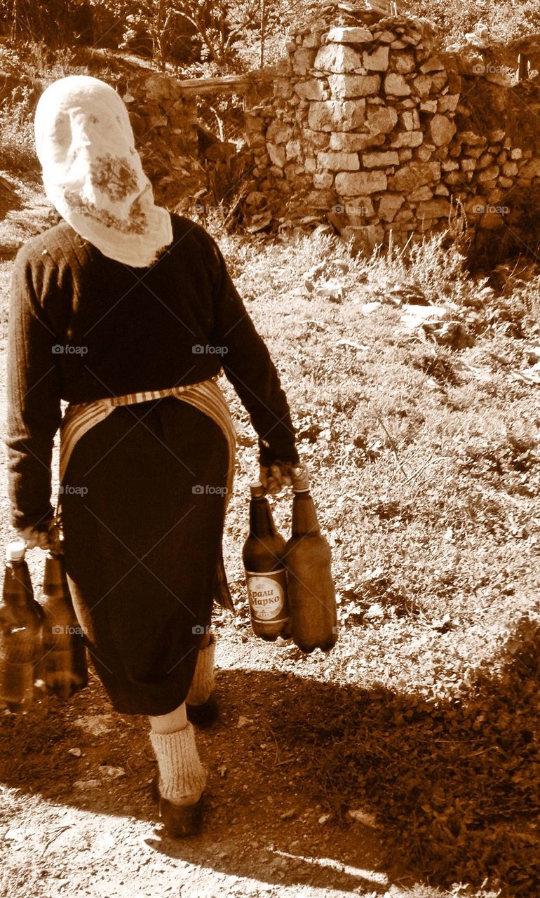 Old lady carrying water bottles