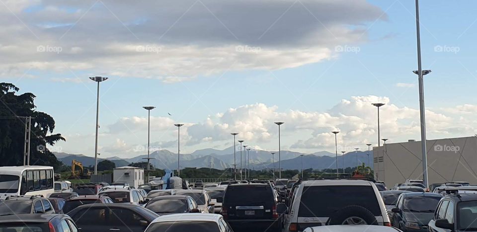 white clouds like a giant wave covering the blue sky and beautiful scenery of the mountains from the parking lot of the mall