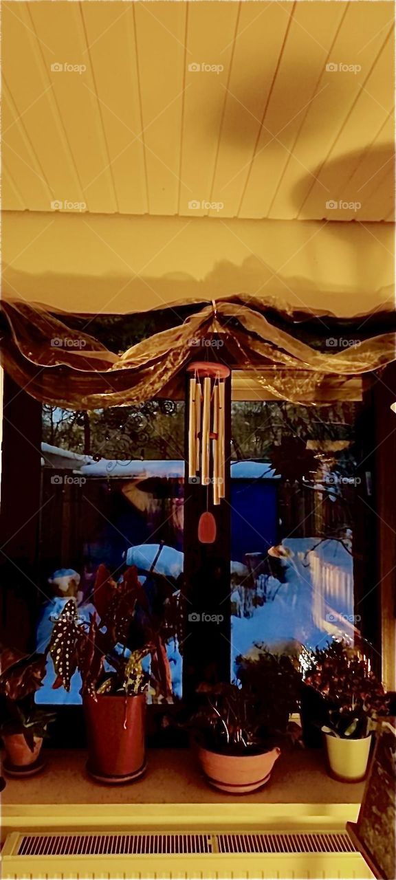 This lovingly decorated window with wind chimes, drapes, beads and more looks out into the winterly garden of the beautiful house in „Bavaria“ that has just now experienced a snowstorm of major proportions in early December 2023. Hypnotic Productions