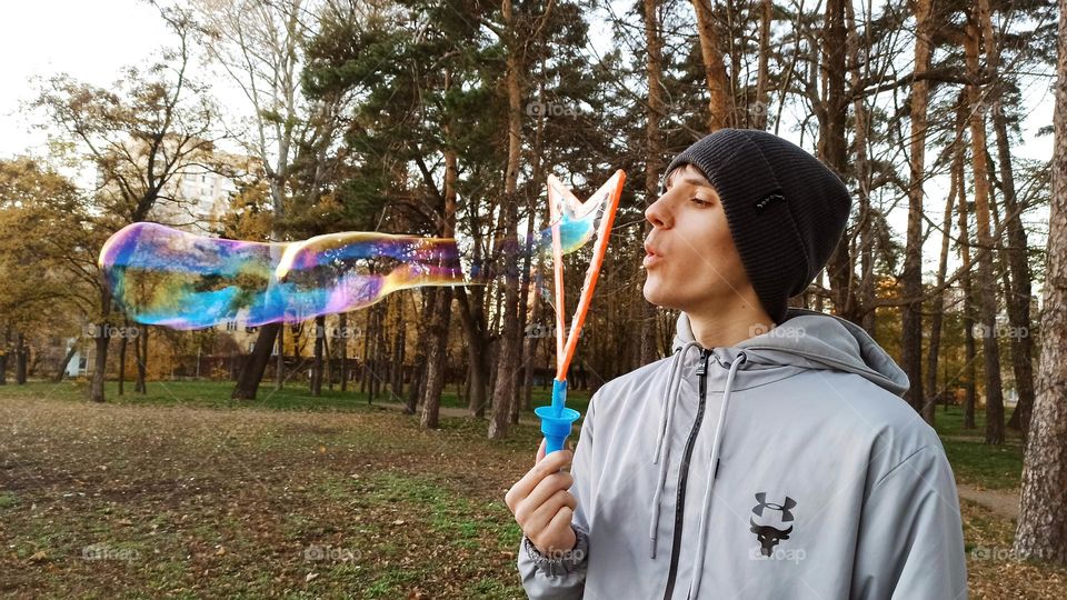 guy blowing bubbles in the park