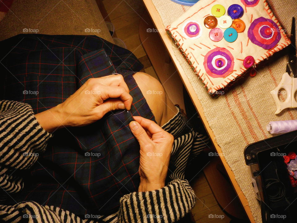 the girl sews a skirt in the autumn evening