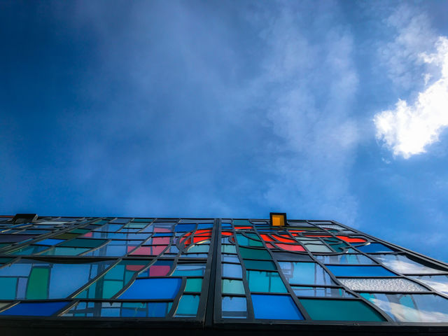 Colorful stained glass greenhouse against blue clear sky 