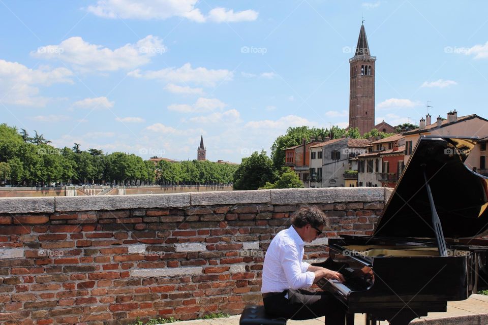 Piano player takes stage on bridge in beautiful Verona