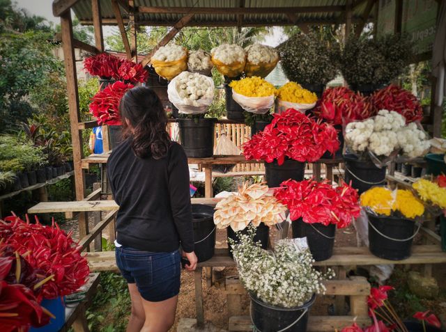 Flower vendor fixing her display