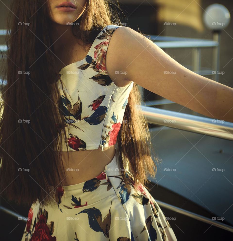 A girl with long beautiful hair on a summer day in the rays of the setting sun.