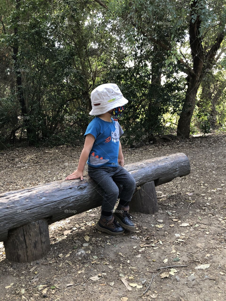 Child sitting on a log in nature