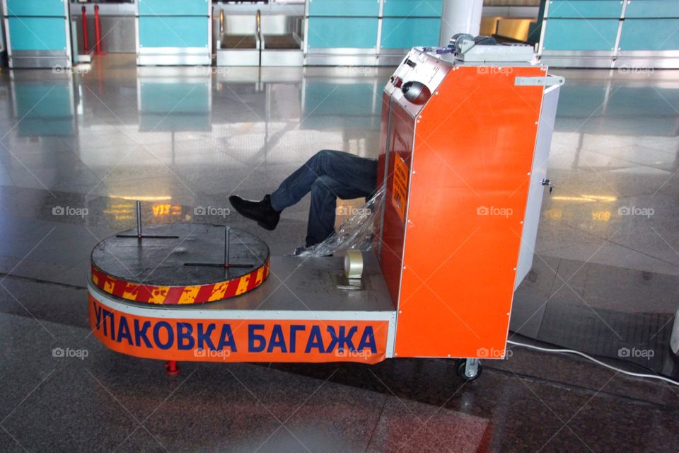  Baggage wrapping at an empty airport with a man waiting for air travellers