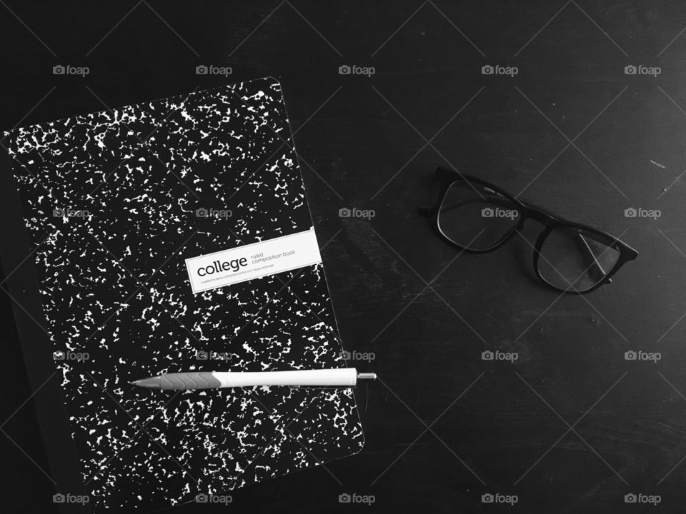 College notebook with pen and glasses