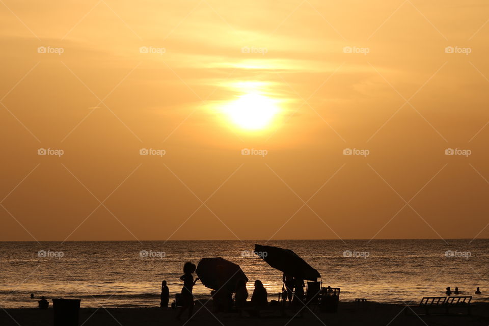 Silhouette of people on the beach at sunset 