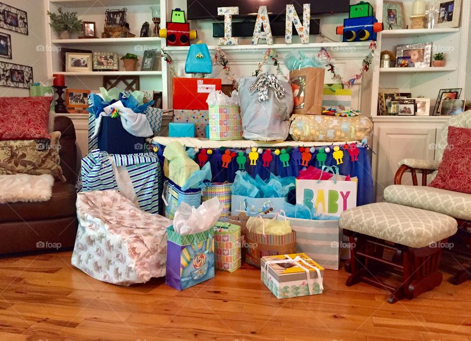 Gifts displayed at a baby shower in bags and boxes for baby boy