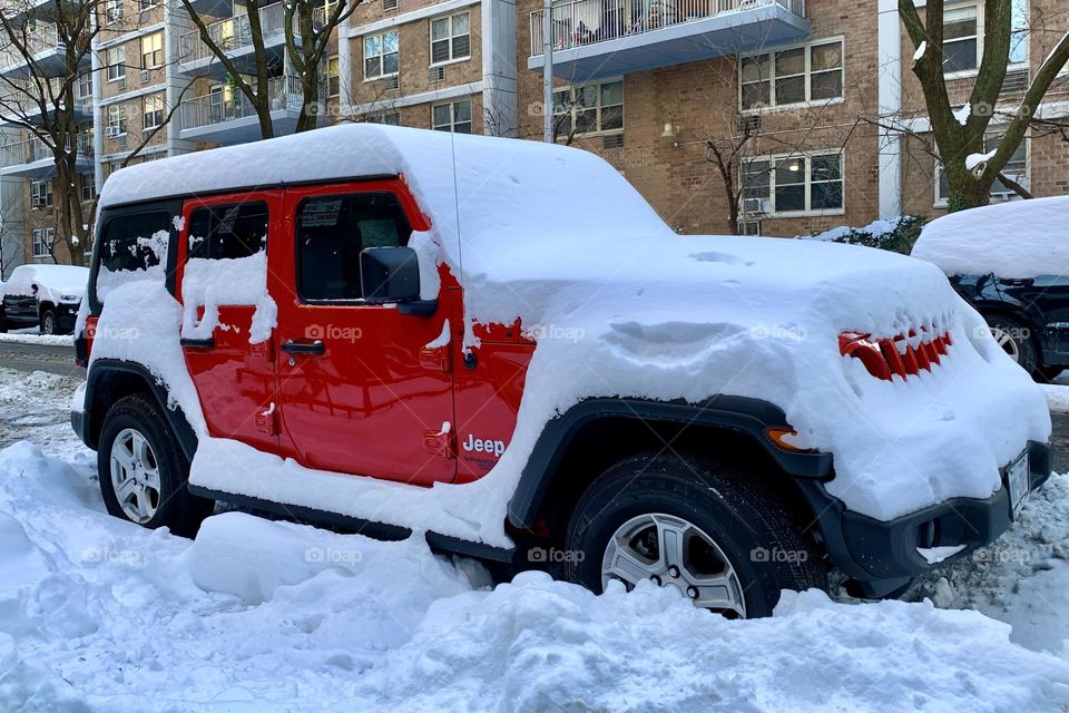 A red car surrounded by snow