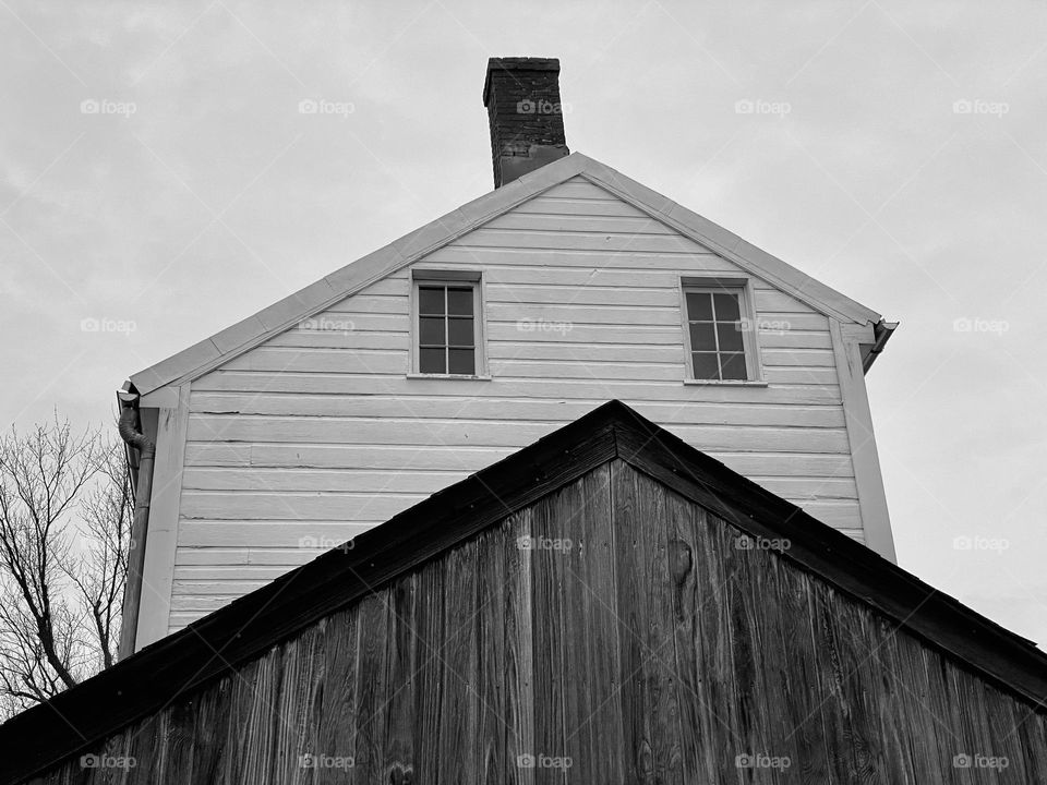 A wooden shed in front of a white house