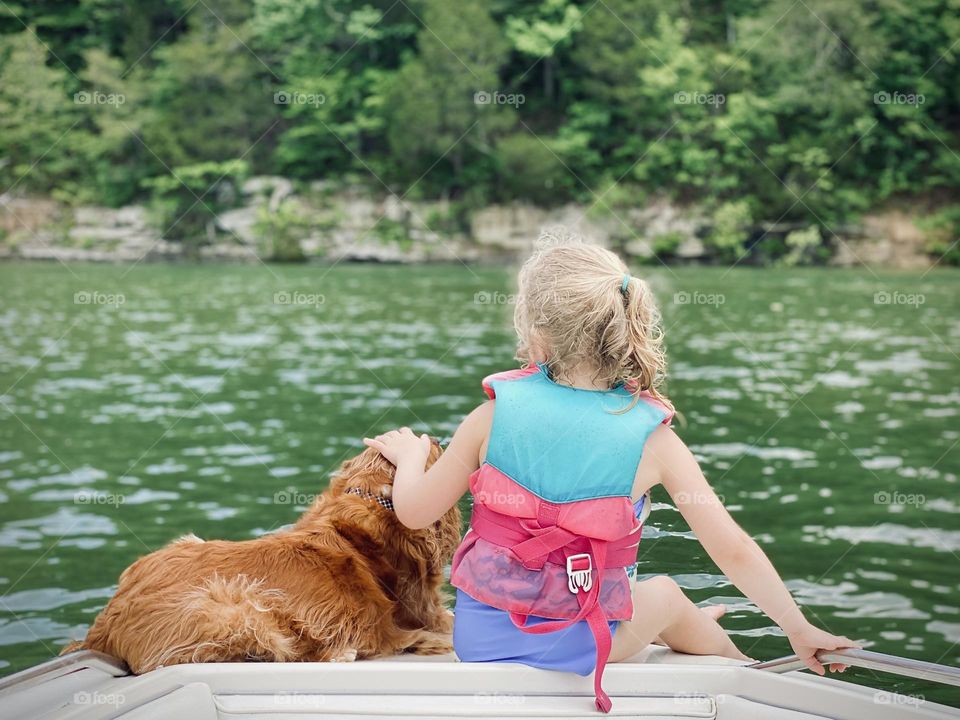 Just a girl and her dog enjoying a moment together out on a boat