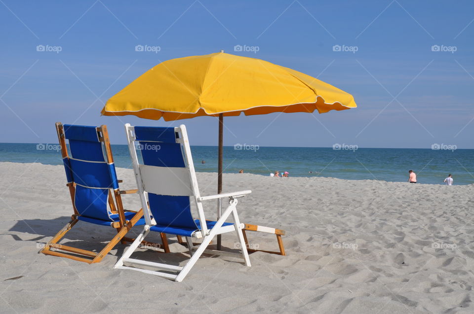 Blue beach chairs and umbrella. 
