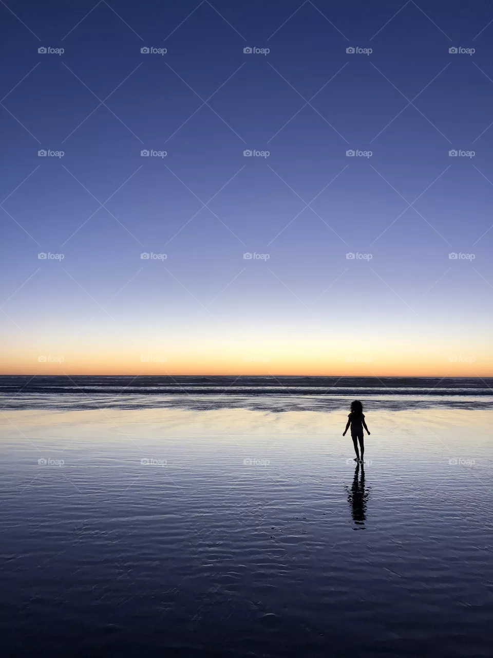 Silhouette of a girl at sunset at the ocean