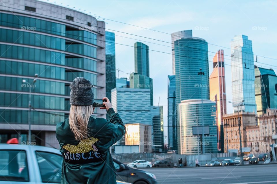 girl taking pictures of a big city