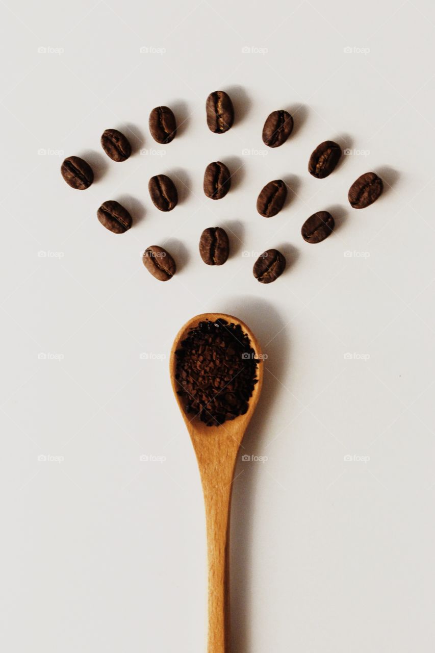 A spoonful of coffee powder and coffee beans arrangement