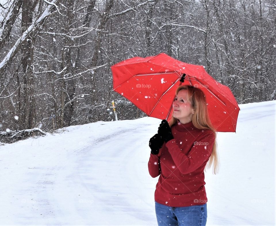 Woman with red Totes umbrella in the snow