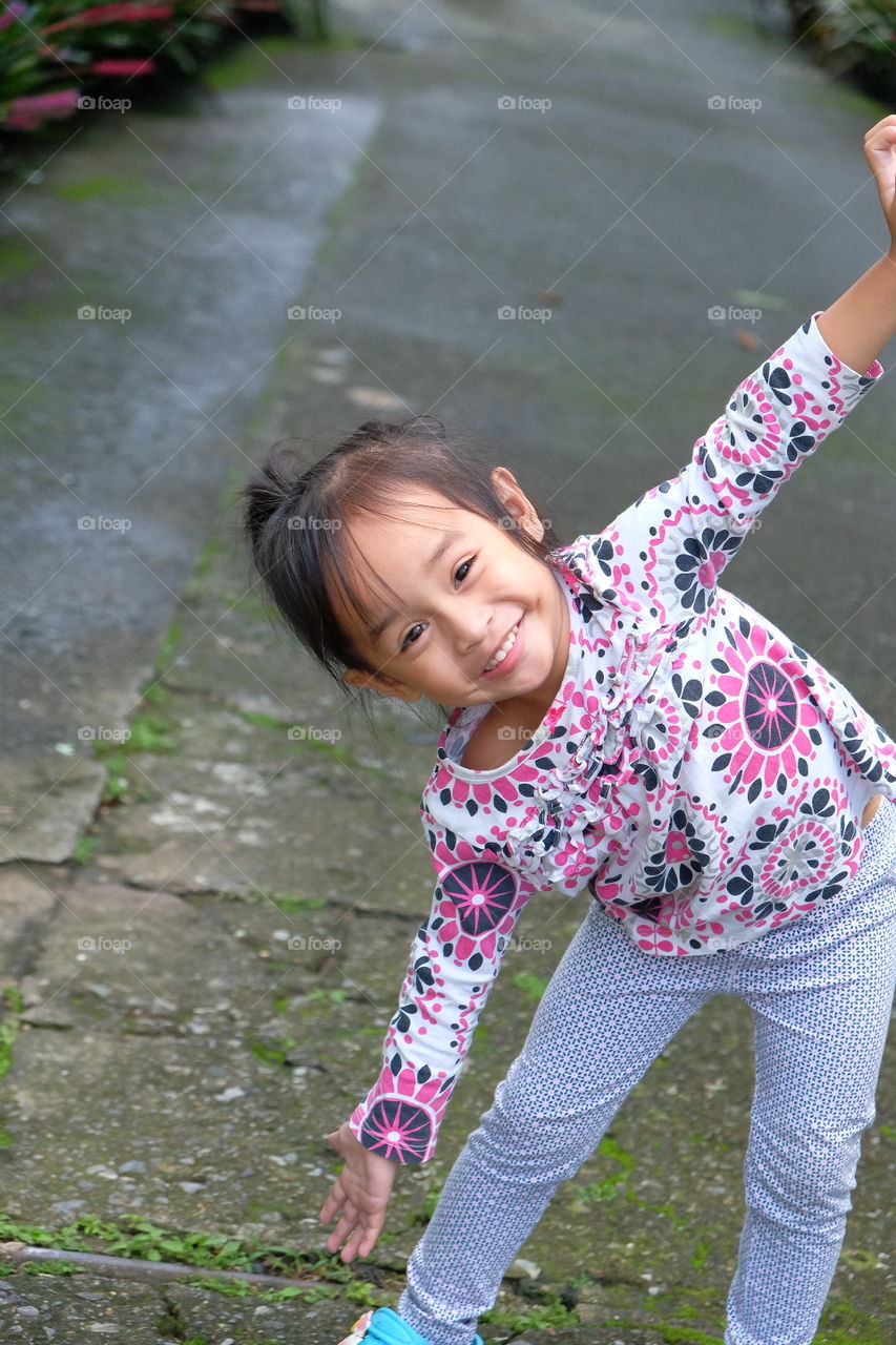 Playful smile. A cheerful child paused for a moment from playing gave her smile and wemt back playing. So innocent soul