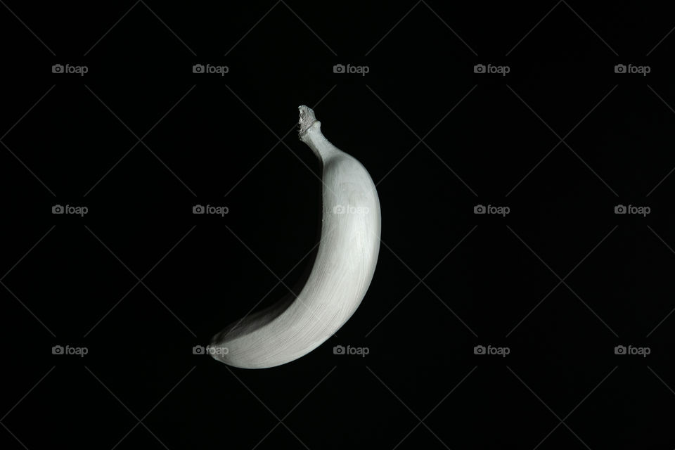 White floating banana on black backgroun. Creative fruit concept