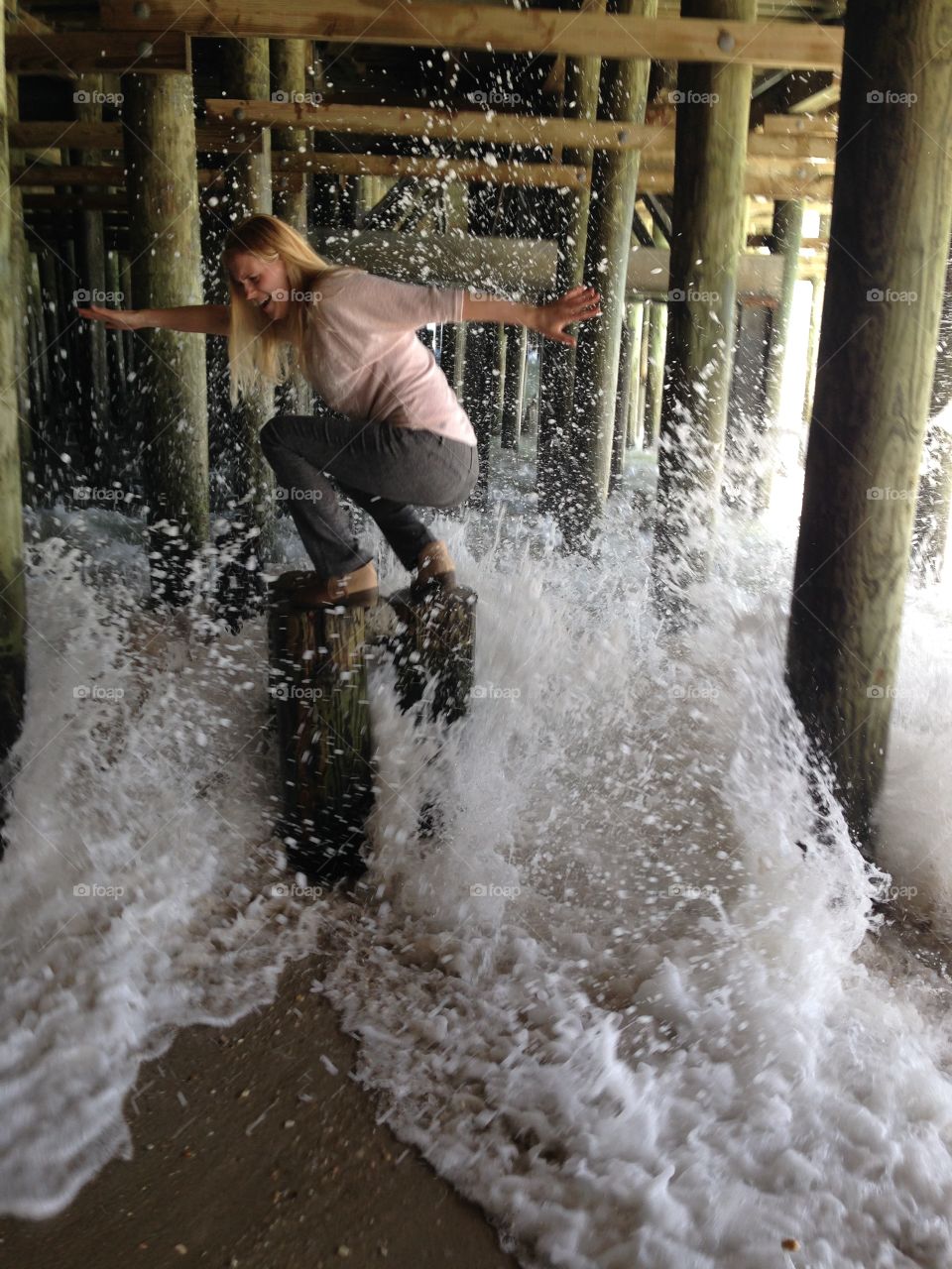 Afraid woman on wooden post under the pier