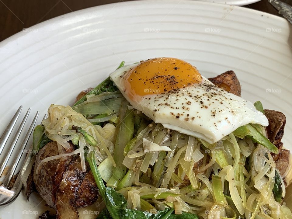 Plate with cocked vegetables and sunny side egg on top