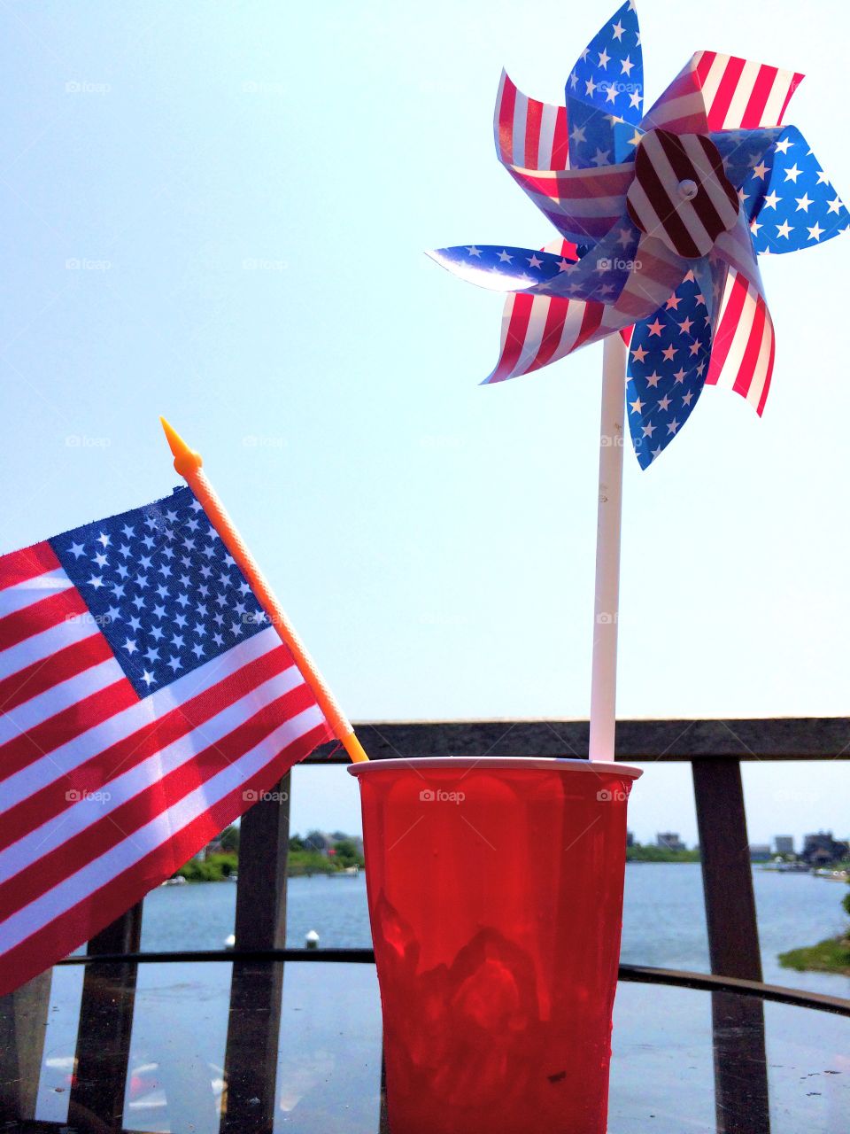 Stars and Stripes 2. Happy Fourth of July!
Small American flag and pinwheel in a red cup, with a small marina in the background.