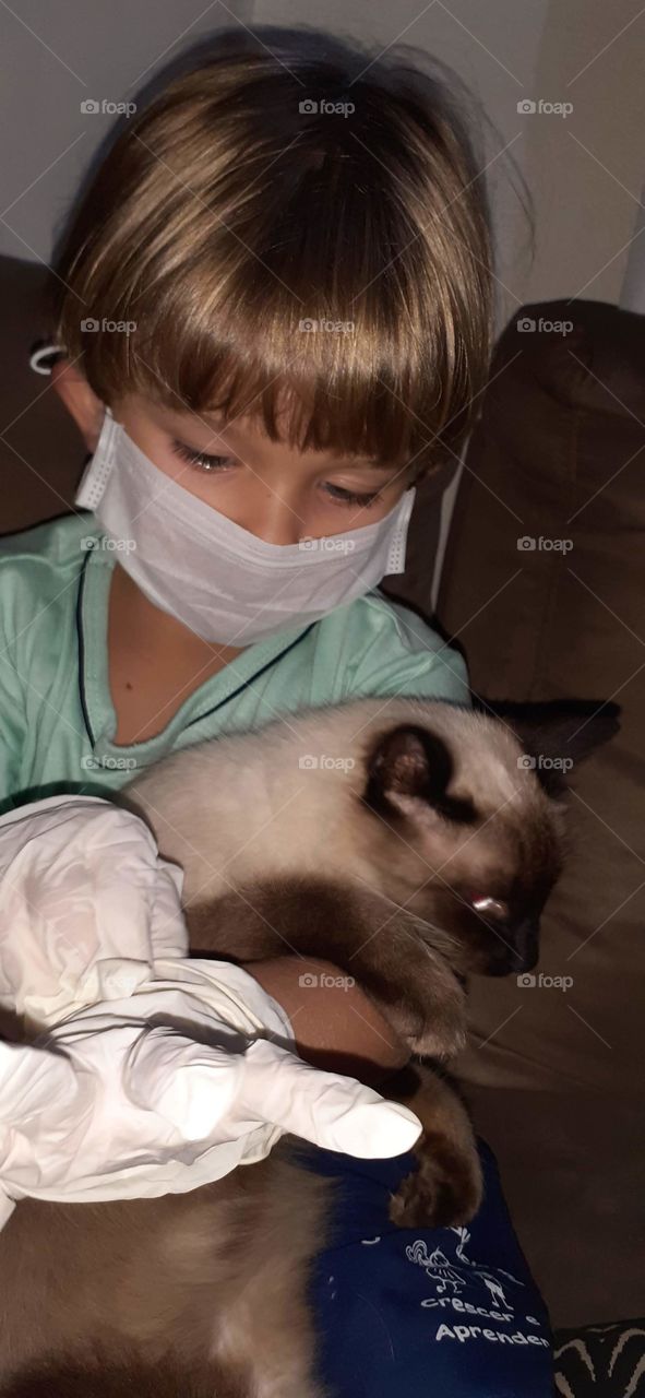 pretty child with mask and glove with the cat.